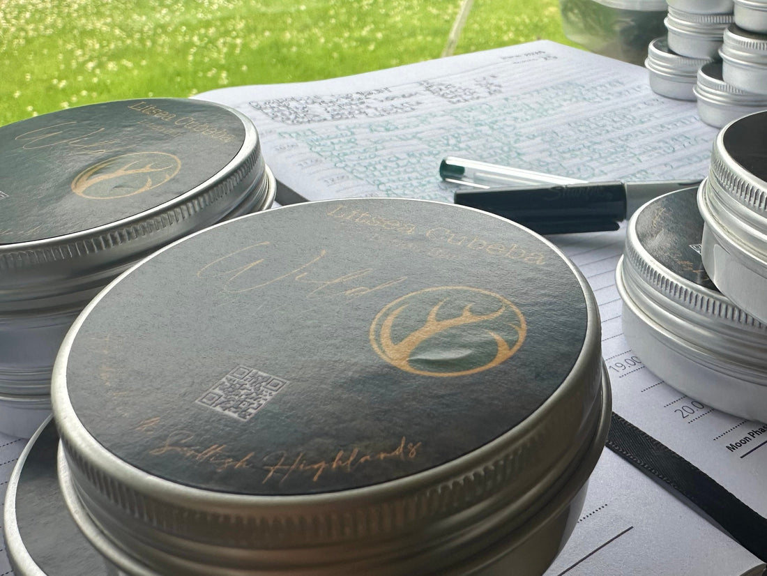 Wild by Nature branded tins on a formulation workbench with handwritten notes