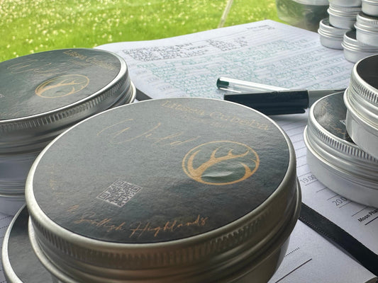 Wild by Nature branded tins on a formulation workbench with handwritten notes